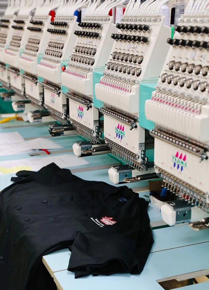 Multi-head embroidery machines stitching logos onto black jackets