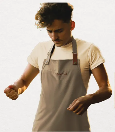 Server in a cream tee and branded linen apron