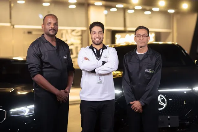 Three Volt Auto staff in black and white uniforms in the showroom
