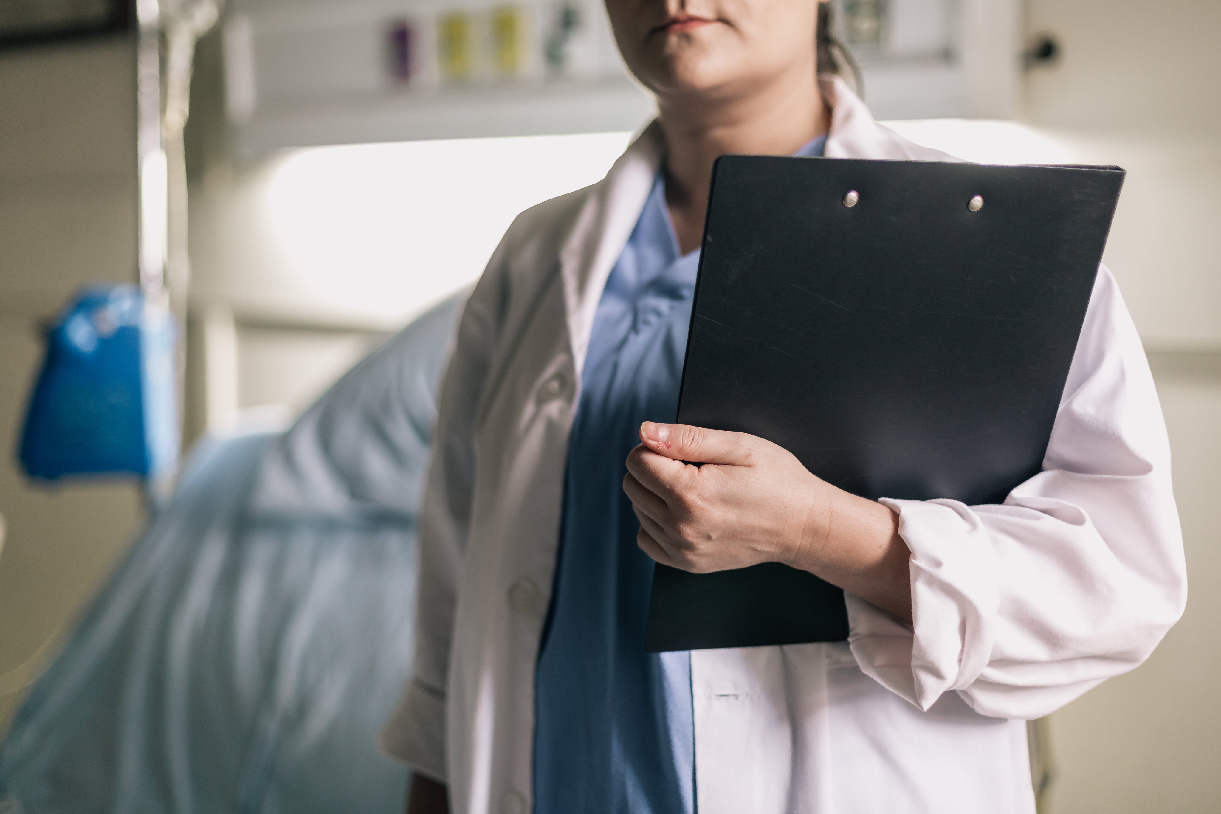 female-medical-professional-holds-clipboard-in-hospital-room.jpg